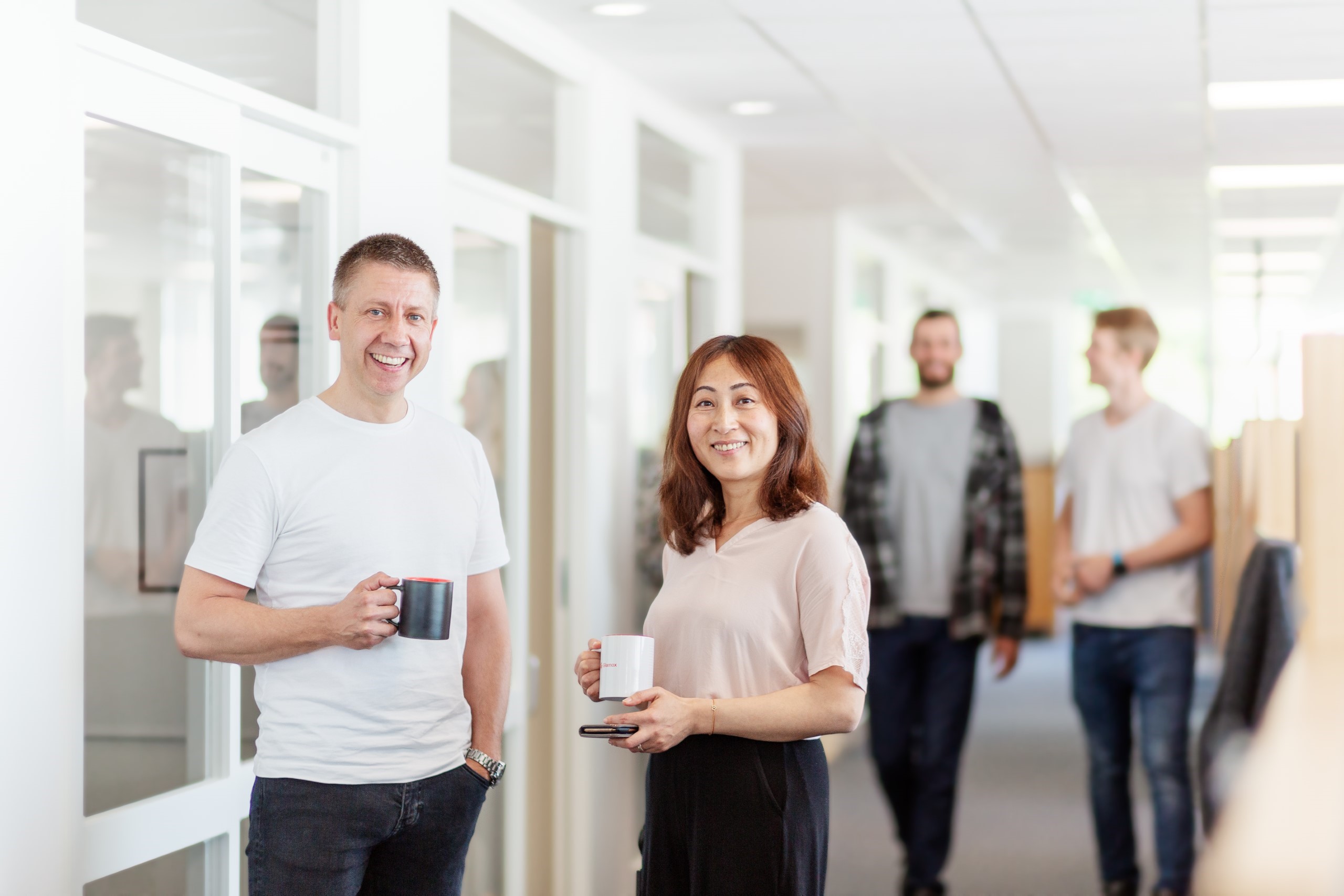 People with coffee cups walking in corridor.jpg