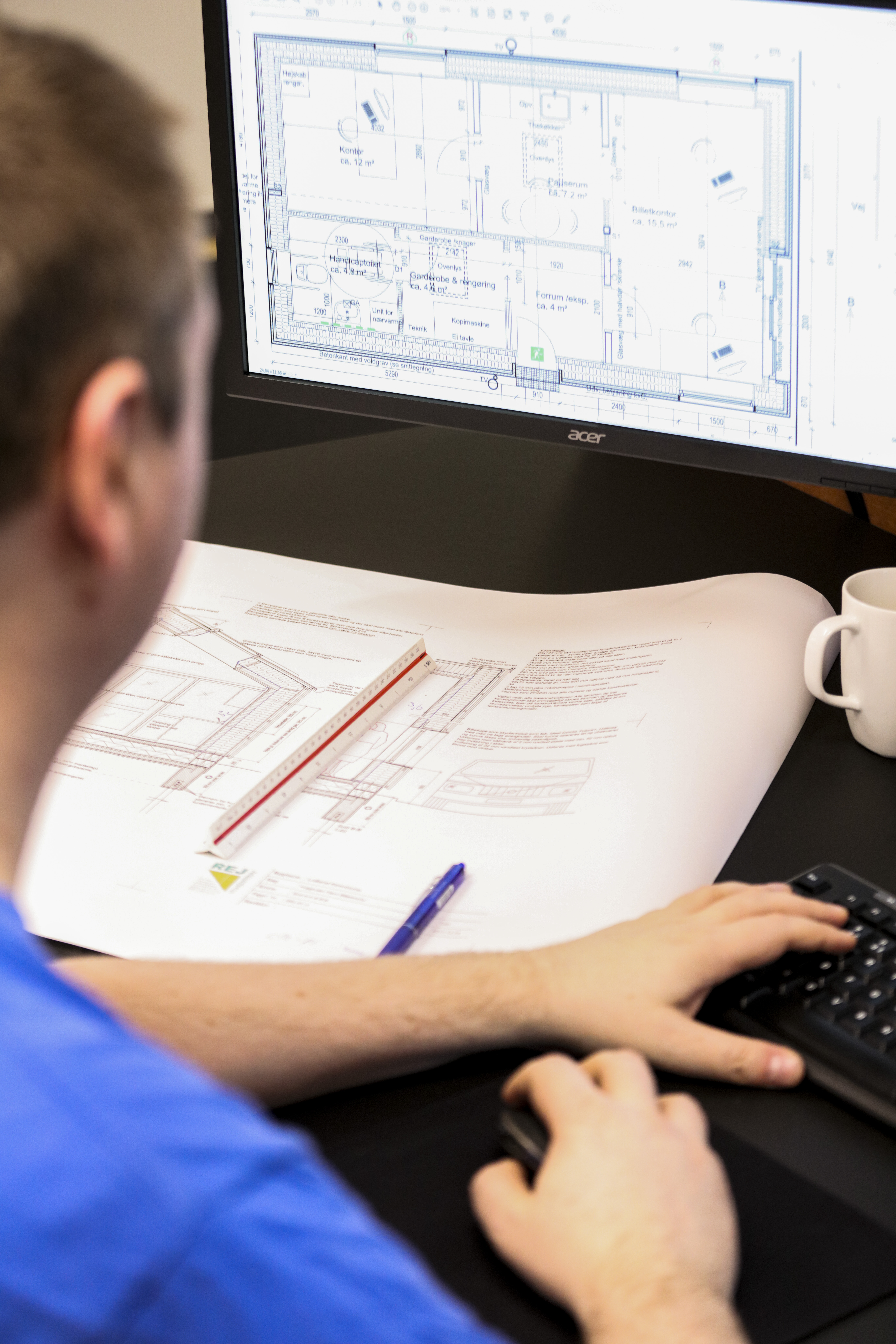 Man working on computer making project drawings